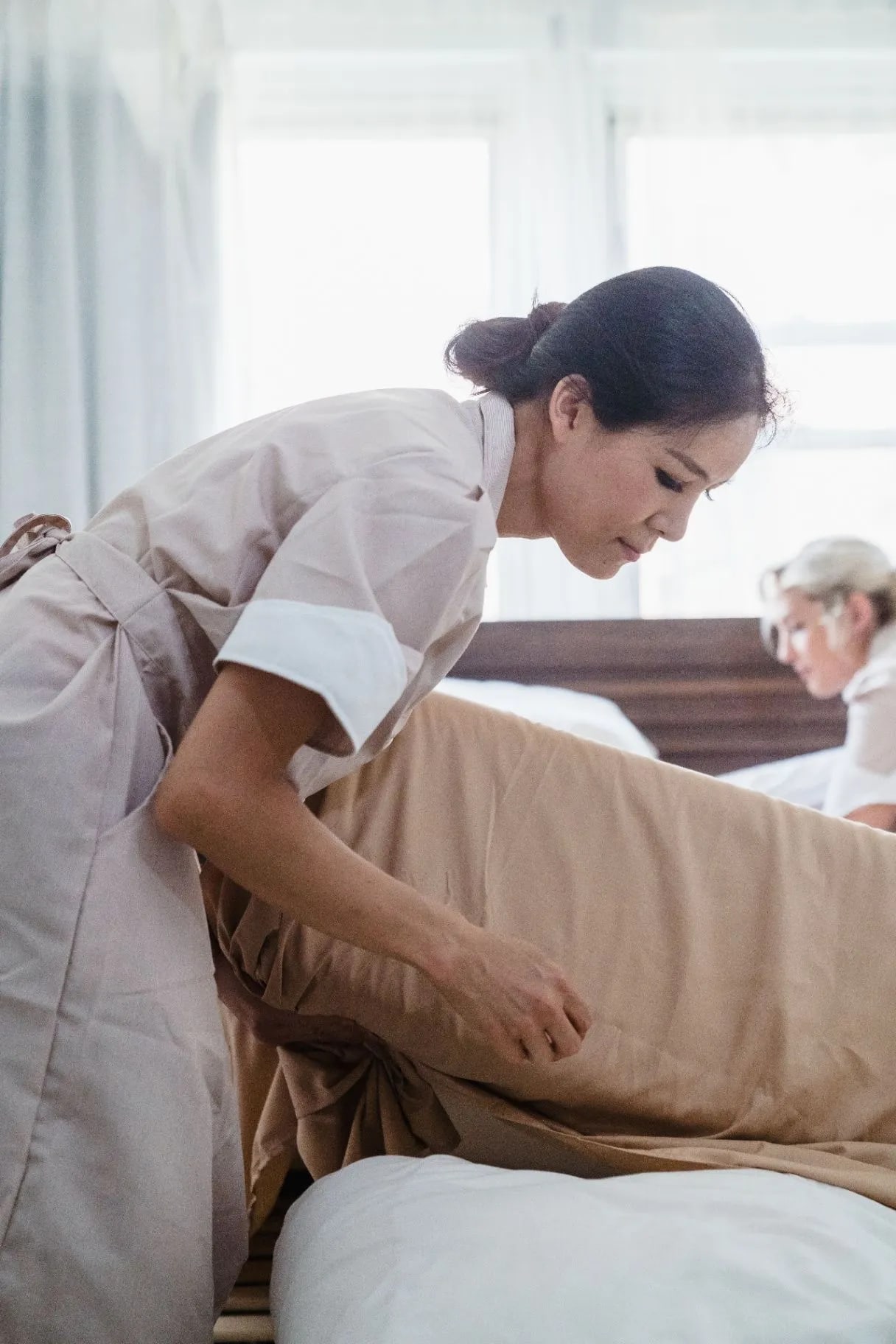 Housekeeper making a hotel bed